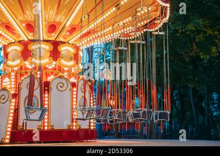 Manège gratuit illuminé de mille feux. Soirée d'été dans le parc d'attractions de la ville Banque D'Images