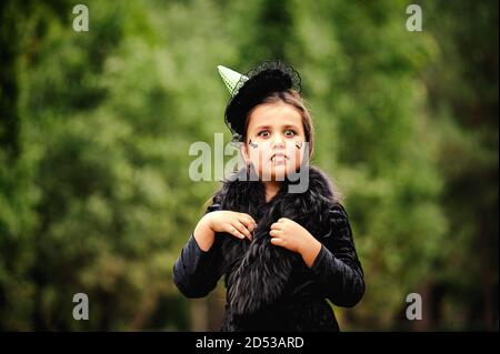 Fille aux cheveux bouclés dans un costume de sorcière pour Halloween Banque D'Images