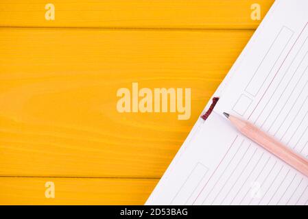 Concept de planification. Haut au-dessus de la vue de dessus de la tête gros plan photo d'un planificateur ouvert et d'un crayon isolé sur fond de bois jaune avec copyspace Banque D'Images