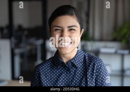 Portrait en tête de jeune employé indien souriant au bureau Banque D'Images