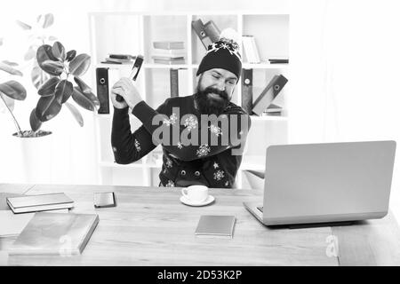 Je déteste. Fou a frappé un ordinateur portable avec un marteau. Businessman brutal avec crazy look. Hipster barbu fou dans l'humeur. Crazy occupé la veille de Noël. Vacances d'hiver nécessaires. Banque D'Images