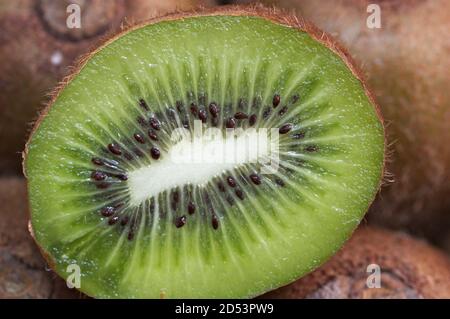 Gros plan d'un kiwi coupé en deux, vous permettant de voir les graines du cœur du fruit Banque D'Images