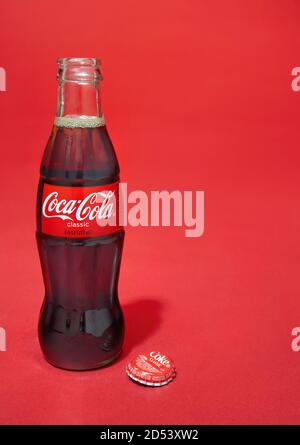 Bouteille de coca-cola en verre ouvert photographiée sur fond rouge Banque D'Images