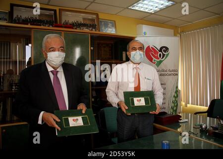 Gaza. 12 octobre 2020. Abdul Latif al-Haj (R), directeur des affaires hospitalières au ministère de la Santé de Gaza, et Maamoun Abu Shahla, président de l'association caritative Gun Palestine, présentent l'accord à Gaza, le 12 octobre 2020. Un organisme de bienfaisance palestinien a signé lundi un accord avec le ministère de la Santé de Gaza pour fournir et installer des panneaux d'énergie solaire financés par la Chine pour un hôpital pour enfants dans la ville de Gaza. Credit: Rizek Abdeljawad/Xinhua/Alamy Live News Banque D'Images