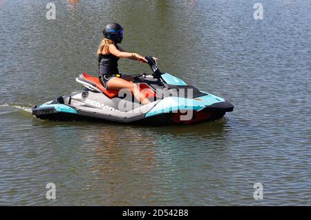 Mariestad, Suède - 23 juin 2020 : une femme pilote de jet ski tournant lentement dans le port. Banque D'Images