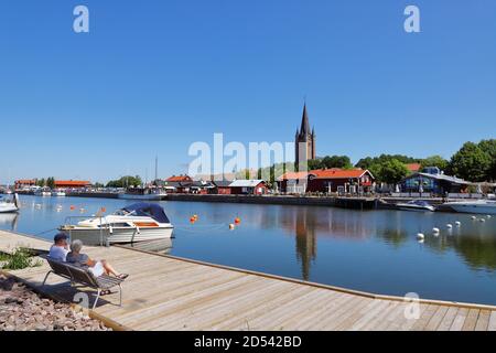Mariestad, Suède - 23 juin 2020 : vue sur le port avec deux personnes assises sur un banc. Banque D'Images