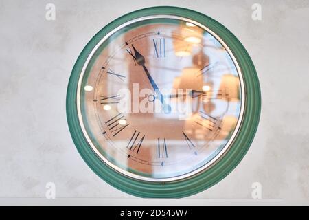 Grande horloge murale qui reflète la chambre. Regardez la lumière de verre des lustres de l'appartement. Banque D'Images