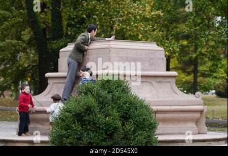 St. Louis, États-Unis. 12 octobre 2020. Un homme place une croix faite de bâtons, dans la base où une statue de Christophe Colomb était autrefois dans le parc Tower Grove, comme la famille se tient près, le jour de Christophe Colomb à Saint Louis le lundi 12 octobre 2020. La statue a été enlevée le 16 juin 2020 après avoir été debout dans le parc pendant 140 ans. Photo par Bill Greenblatt/UPI crédit: UPI/Alay Live News Banque D'Images