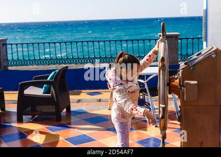 jolie petite fille tenant un bateau volant dans un parc d'attractions Banque D'Images