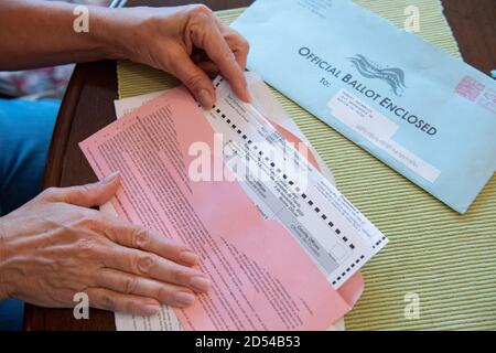 Austin, Texas, le 12 octobre 2020: La femme enferme son bulletin de vote par courrier dans l'enveloppe officielle fournie. Le formulaire doit être soit envoyé par la poste, soit déposé en personne à temps pour être compté avant le jour d'élection du 3 novembre. Banque D'Images