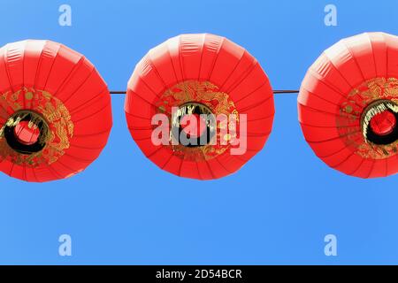 Trois lanternes chinoises rouge et or suspendues sur un fil au-dessus d'une rue à Chinatown, San Francisco, CA, États-Unis Banque D'Images