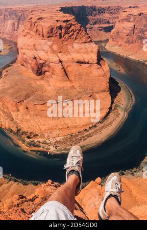 Randonneur aventureux assis au bord de la falaise dans le Horseshoe Bend en Arizona, États-Unis Banque D'Images