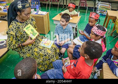 Miami Florida,Overtown,Frederick Douglass Elementary School,enseignante tenue habillée,littéraire costume lecture livre caractère fictif,Hispanic Black AF Banque D'Images