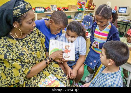 Miami Florida,Overtown,Frederick Douglass Elementary School,enseignante tenue habillée,littéraire costume lecture livre caractère fictif,Hispanic Black AF Banque D'Images