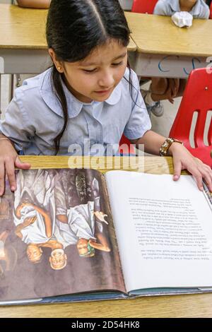 Miami Florida,Overtown,Frederick Douglass Elementary School,Hispanic Student Students girl girls,American Americans Class classroom Reading book, Banque D'Images