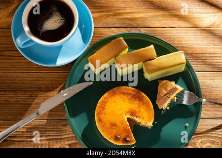 manger un morceau de gâteau au fromage avec des gâteaux au matcha et une tasse de café à l'arrière-plan dans une composition horizontale matinale ensoleillée Banque D'Images