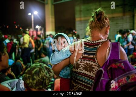 Une femme transportant son enfant attend à la gare routière avant de rejoindre une caravane de migrants sur le long trajet jusqu'à la frontière des États-Unis. Les migrants fuient l'extrême pauvreté et la violence des gangs, espérant trouver une vie meilleure aux États-Unis, ils doivent parcourir plus de 3,000 kilomètres à travers le Guatemala et le Mexique, souvent sans rien d'autre que les vêtements sur leur dos, pour atteindre la frontière à Tijuana, au Mexique, où leur sort est indécis. Banque D'Images