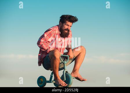 Portrait d'un homme barbu cycliste, hipster fou s'amuser avec le vélo à l'extérieur. Banque D'Images