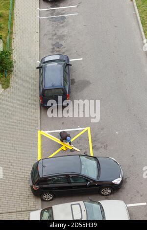 Le travailleur applique des marques de peinture jaunes sur l'asphalte. Service urbain professionnel, vue de dessus Banque D'Images