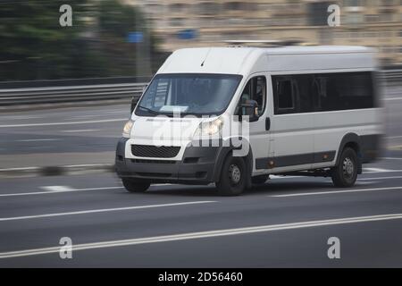 Minibus blanc va sur la ville street Banque D'Images