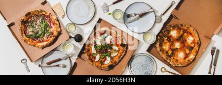 Plat de pizzas dans des boîtes, des boissons au citron et des couverts Banque D'Images