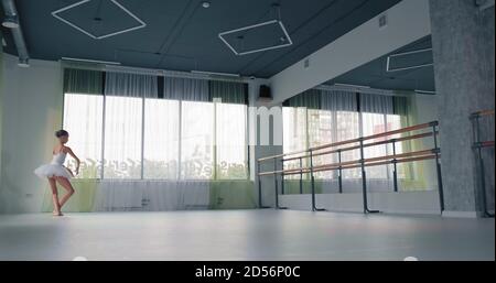 Jeune fille talentueuse en tutu blanc danse classique Ballet look au grand miroir sur le mur dans le studio spacieux Banque D'Images