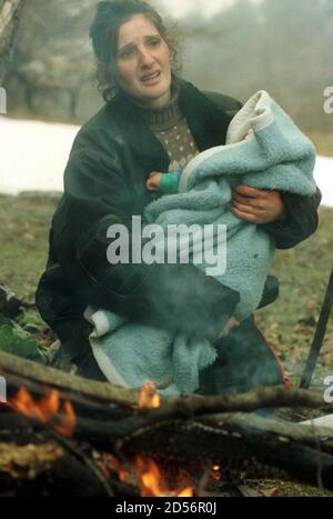 An Ethnic Albanian Refugee Woman Holds Her Baby By A Fire After They Were Allowed To Enter Macedonia March 30 In The Mountainous Region Near The Border Crossing Of Blace The 2 000