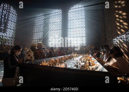Aparecida, Brésil. 12 octobre 2020. Les croyants éclairent leurs bougies et prient dans la salle des bougies de la Basilique de Nossa Senhora Aparecida, le jour de Nossa Senhora Aparecida, le Saint patron du Brésil. Pour la première fois dans l'histoire de la basilique, en raison de la pandémie de Corona, les masses ont dû être célébrées derrière des portes fermées ou en présence d'un petit nombre de personnes. Credit: Fernando Souza/dpa/Alay Live News Banque D'Images
