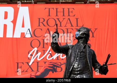 Londres, Royaume-Uni. - 5 octobre 2020 : une statue masquée devant une bannière annonçant l'exposition d'été traditionnelle de l'Académie royale, reportée jusqu'en octobre en raison de la pandémie du coronavirus. Banque D'Images