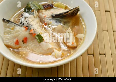 Tête de poisson de saumon épicée et champignon de la paille à Tom Yum soupe sur bol Banque D'Images