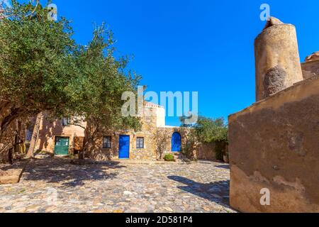 Monemvasia, Péloponnèse, Grèce vue sur la rue avec de vieilles maisons avec portes bleues Banque D'Images
