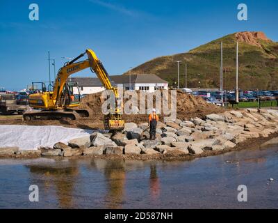 La construction de défenses contre les inondations le long de Skelton Beck en utilisant lourd équipement de terrassement et grands blocs de pierre Banque D'Images