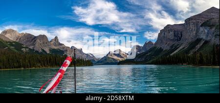 Drapeau canadien sur un bateau sur le lac Maligne avec Hall of the Gods in the loin, Canadian Rocky Mountains, Alberta, Canada Banque D'Images