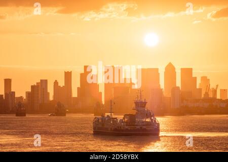 Ferry de Woolwich passant devant la barrière de la Tamise et Canary Wharf au crépuscule, Londres, Angleterre, Royaume-Uni Banque D'Images