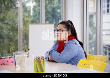 Fille asiatique avec le syndrome de Down en classe. Banque D'Images