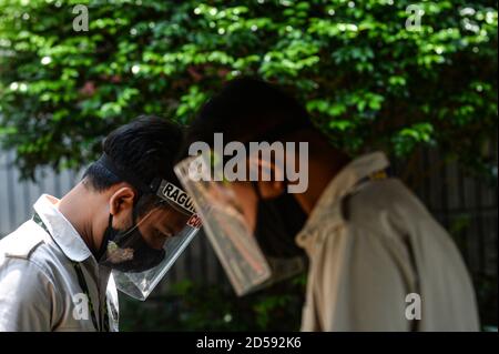 Jakarta, Indonésie. 13 octobre 2020. Les membres du personnel portant un masque facial et un masque facial travaillent au zoo de Ragunan à Jakarta, en Indonésie, le 13 octobre 2020. Le zoo de Ragunan à Jakarta a rouvert ses portes au public mardi. Credit: Agung Kuncahya B./Xinhua/Alay Live News Banque D'Images