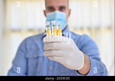 Portrait d'un médecin tenant trois échantillons de laboratoire Banque D'Images
