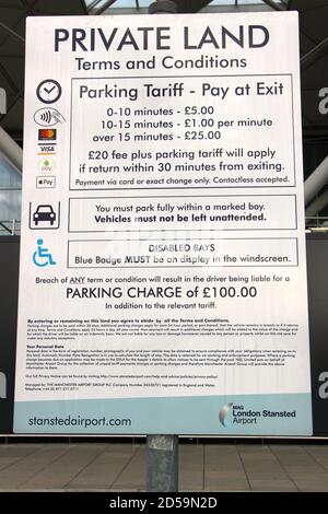 Signe de terrain privé avec les termes et conditions et les frais pour stationnement dans la zone de dépôt des passagers à l'extérieur du terminal Bâtiment de l'aéroport de Londres Stansted Banque D'Images