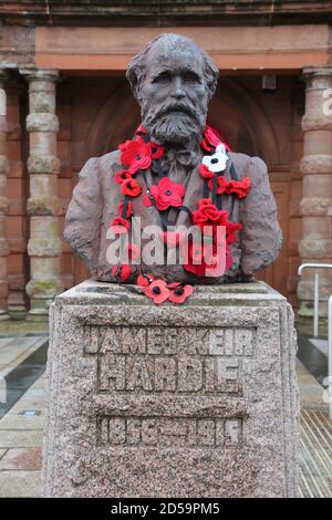 Scotland, Ayrshire,Cumnock , James Kier Hardie buste avec des coquelicots.James Keir Hardie était un syndicaliste et un politicien britannique. Il a été l'un des fondateurs du Parti travailliste et a été son premier leader parlementaire de 1906 à 1908. Hardie est né à Newhouse, dans le Lanarkshire. Il a commencé à travailler à l'âge de sept ans, et à partir de 10 ans, il a travaillé dans les mines de charbon du Lanarkshire.leader britannique du travail, d'abord pour représenter l'ouvrier au Parlement comme indépendant Banque D'Images