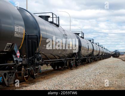 Wagons-citernes noirs du type utilisé pour le transport des produits pétroliers. Plusieurs voitures sont visibles sur deux ensembles de voies distincts. Marquage d'identification Banque D'Images