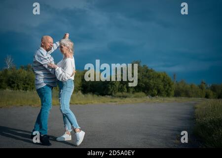 un couple senior heureux a une rencontre romantique et danse en plein air à été Banque D'Images