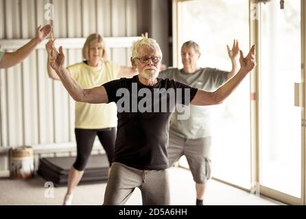 Groupe d'aînés de la classe Tai Chi s'exerçant dans un mode de vie actif à la retraite. Avantages pour la santé mentale et physique de l'exercice physique et de la condition physique chez les personnes âgées Banque D'Images