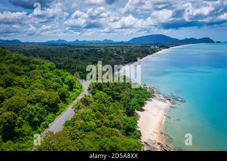 Vue aérienne de la route entre le cocotier et le grand océan en journée à Nakhon si Thammarat, Thaïlande Banque D'Images