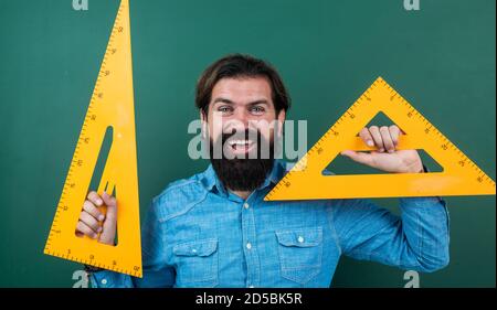 homme heureux avec la taille mesurée sur l'outil de mathématiques de règle de triangle, école de mathématiques. Banque D'Images