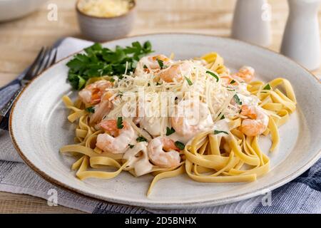 alfredo fettuccine crémeux avec crevettes et parmesan râpé sur une assiette. Vue en gros plan Banque D'Images