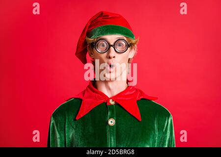 Magic x-mas réductions concept petit gars elf look étonné dans lunettes de style geek isolées sur fond de couleur brillante Banque D'Images