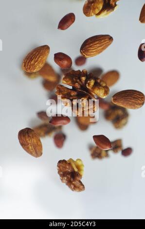 Noix dans l'air sur fond blanc, écrous volants. Alimentation saine, alimentation, protéines, amandes, noix et noisettes cacahuètes Banque D'Images
