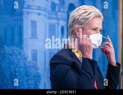 Schwerin, Allemagne. 13 octobre 2020. Manuela Schwesig (SPD), première ministre de Mecklembourg-Poméranie occidentale, prend son protecteur de bouche et de nez avant une conférence de presse. Mecklembourg-Poméranie occidentale maintient sa position malgré les critiques massives de l'interdiction d'hébergement pour les touristes des zones à risque de corona. Credit: Jens Büttner/dpa-Zentralbild/dpa/Alay Live News Banque D'Images