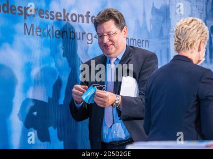 Schwerin, Allemagne. 13 octobre 2020. Manuela Schwesig (SPD), Premier ministre de Mecklembourg-Poméranie occidentale, et Reinhard Meyer (SPD), ministre des Finances de Mecklembourg-Poméranie occidentale, changent de place lors d'une conférence de presse. Mecklembourg-Poméranie occidentale maintient sa position malgré les critiques massives de l'interdiction d'hébergement pour les touristes des zones à risque de corona. Credit: Jens Büttner/dpa-Zentralbild/dpa/Alay Live News Banque D'Images