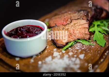 Sauce à la cerise avec veau moyen rare cuit, gros sel, épices et feuilles d'arugula Banque D'Images